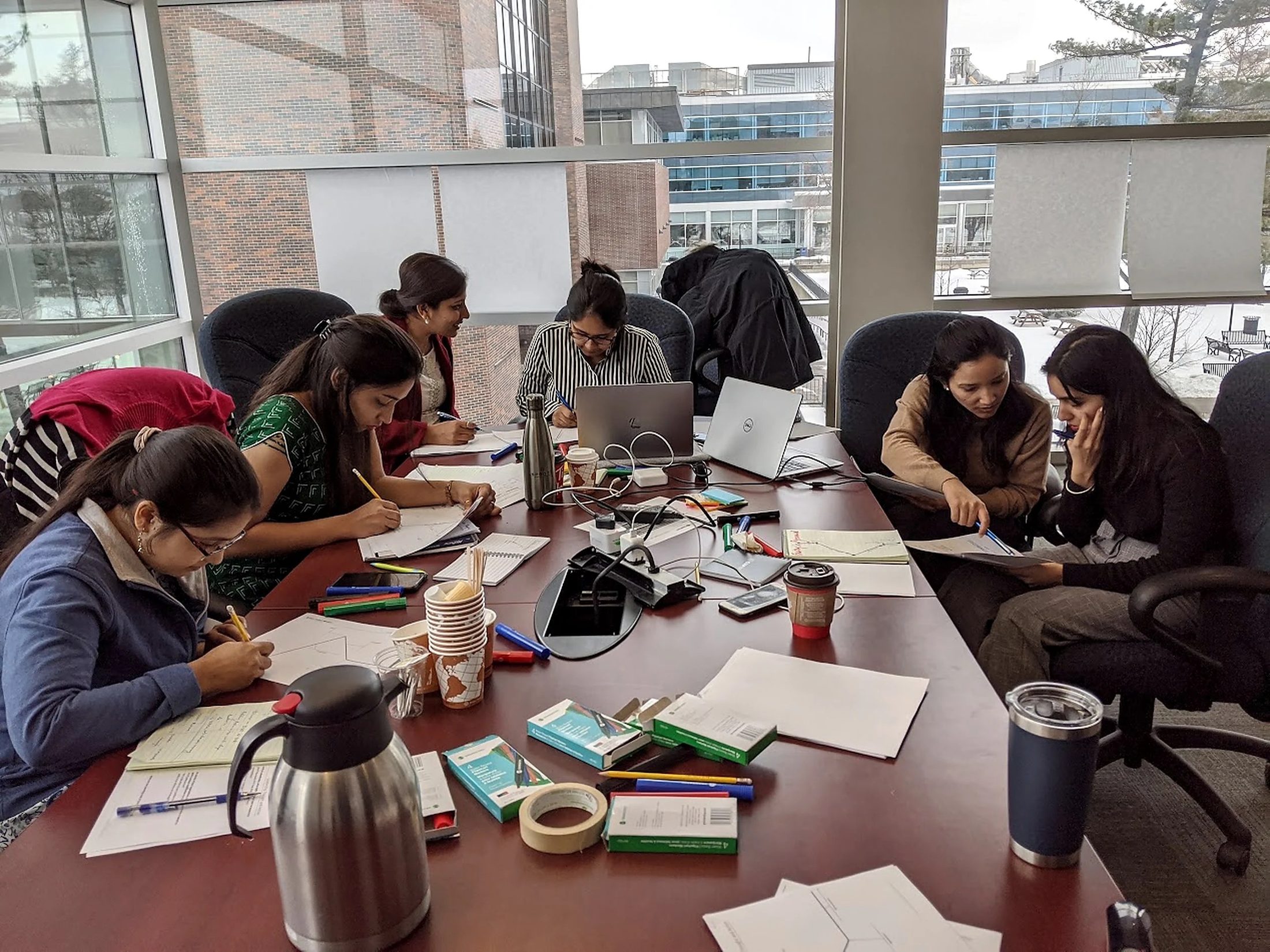 Participants working with cards and paper around a boardroom table